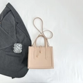 Detail view of a beige square tote bag with drawstring decor on white fabric background - Khaki