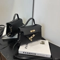 Chic black mini trapezoid handbag with top handle and crossbody strap in grainy leather - Black