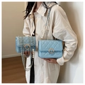 Macro detail of blue quilted leather bag with pearl buckle and golden chain strap - Small / Blue