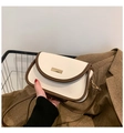 Nahaufnahme der beigen Ledertasche mit braunem Rand und Goldverschluss im Herbstlook - Weiß