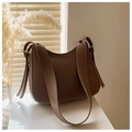Close-up of brown leather hobo bag with wide shoulder strap and gold hardware detail - Brown