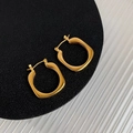 Minimalistische onregelmatige geometrische gouden oorbellen op zwart leer - Goud