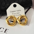 Dettaglio macro di orecchini a triplo cerchio intrecciato placcati oro su cartoncino - Oro