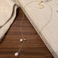 Detalle de un collar de perlas doradas en forma de Y con cierre de mosquetón ajustable - Dorado