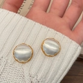 Macro shot of French luxury style round earrings with gold trim and silver pearl inlay - Brushed Two-tone Round