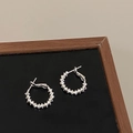 Close-up of silver beaded hoop earrings with textured finish on black display board - Bumpy Texture Bead Style (A-1204)