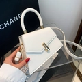 Minimalist white geometric handbag with gold T-clasp and elegant top handle display - White