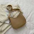 Borsa a secchiello kaki minimalista con dettagli argento su maglia bianca - Cachi