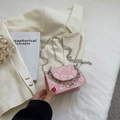 Rosa Mini-Umhängetasche mit 3D-Blumenmuster und Silberkette auf hellem Blazer - Rosa