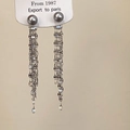 Detalle de pendientes largos de borla con perlas grises y cadenas de metal plateado - Pendientes de borlas plateadas