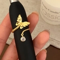 Macro detail of golden butterfly ring with sparkling zircon drop and textured metal wings - Adjustable Open / Golden Butterfly Ring