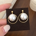 Detail van elegante parel hanger oorbellen aan een gouden ring met een oorsteker - Gouden Parel Ring Stijl