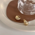 Elegante vergoldete Creolen mit Zirkonia-Sternen auf einer stilvollen Lederunterlage - Goldene Ohrringe