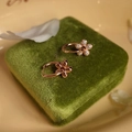 Dettaglio di orecchini a fiore in oro rosa con diamanti su cofanetto verde - Orecchini Oro Rosa