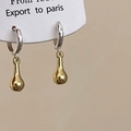 Nahaufnahme von zweifarbigen Tropfenohrringen mit silbernen Reifen und goldenen Anhängern - Goldener Wassertropfen-Anhänger (Silberner Haken)
