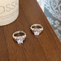 Détail de créoles argentées avec zircon ovale dans une monture robuste à quatre griffes - Argenté