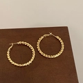 Détail de créoles torsadées en spirale finition dorée polie sur surface en bois - Style de Texture Tressée Torsadée Fine (A-1180)