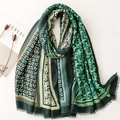 Green linen-feel scarf with gold leaf patterns and tassel edges on textured background - Green