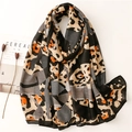 Abstract leopard print scarf with geometric patterns in black, khaki, and bright orange - Black