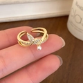 Dettaglio macro di un anello dorato a coda di pesce con zircone e perla bianca - Anello Coda di Pesce Zircone Oro