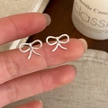 Détail de boucles d'oreilles nœud argentées montrant un design linéaire délicat - Boucles d'Oreilles Clous Nœud Enroulé Linéaire Argentées (A-1428)