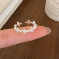Elegante anillo ajustable de plata con flores de circonita usado en la mano - Plateado