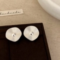 Macro detail of silver pleated ruffle stud earrings with concentric texture on brown velvet - Silver