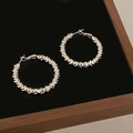 Close-up of silver double spiral hoop earrings with textured finish on black surface - Cracked Fragmented Texture (A-1131) / Silver