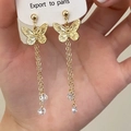 Macro detail of gold butterfly earrings with long tassels and sparkling zircon crystals - Gold Butterfly Tassel Earrings