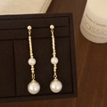 Dettaglio di eleganti orecchini d'oro con trama a spirale e perle stratificate - Orecchini a Bottone con Nappa Dorata