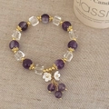 Detailansicht eines Kristallarmbands mit lila Perlen und Muschelblüten-Anhängern - Amethyst Armband