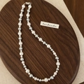 Detail of mixed-color pearl necklace with white and grey pearls on a wooden tray - Grey Mixed Pearl Necklace