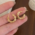 Close-up of golden C-shaped hoop earrings with layered spiral texture and brushed finish - 1.7cm/3.00g / Gold (1.7cm)