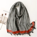 Sciarpa in cotone e lino a quadri con bordo rosso e nappe su un pulito sfondo bianco - Nero e Rosso