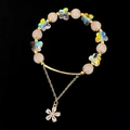 Macro-opname van roze kristallen kralen, iriserende vlinders en een diamanten bloemenhanger - Rozenkwarts Armband
