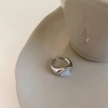 Detalle del anillo minimalista de ojo de gato plateado sobre una bandeja cerámica - Plata Ojo de Gato