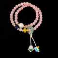 Detail van de dubbellaagse rozenkwarts armband met parel en vlinder hanger sieraad - Rozenkwarts Dubbellaagse Armband