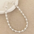 Detailed view of pearl necklace with rhinestone sphere beads on a ceramic plate - White Pearl Necklace