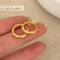 Orecchini a cerchio in bambù oro opaco minimalisti tenuti in mano per un look chic - Oro Opaco