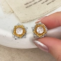 Pendientes de flor bicolor en oro y plata con circonitas sobre una bandeja de cerámica - Bicolor Oro y Plata