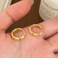 Goldene Creolen mit Bambus-Textur in der Hand für ein stilvolles geometrisches Design - Bambus Gelenk Hoop Stil / Gold