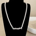 Luxury pearl necklace featuring a diamond-encrusted snake pendant with green gem eyes - Silver