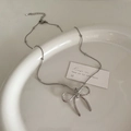 Close-up of silver bow pendant necklace with small metal beads on a ceramic plate - Bowknot Silver Bead Chain / Silver (Bead Chain Style)