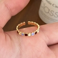Detail of gold open ring featuring colorful enamel squares worn on a hand - Colorful Enamel Ring