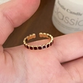 Detail view of gold open ring with dark red enamel inlay on a person's finger - Red Enamel Ring