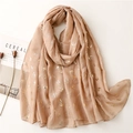 Detail eines beige Schals mit goldenem Schwalben-Print, Magazin und Trockenblumen Deko - 180*90CM / Khaki
