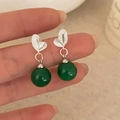 Elegant silver leaf earrings with green agate beads held in hand for size reference - Silver Leaves