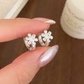 Orecchini a cerchio a fiore in argento con zircone, mostrati a mano per evidenziare la misura - Argento