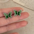 Macro detail of green crystal butterfly earrings held by hand to show fine craftsmanship - Silver Butterfly Style (A-1006)