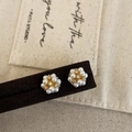 Dettaglio di orecchini a grappolo con perle bianche e zirconi con finitura dorata - Orecchini a Lobo con Perla Bianca